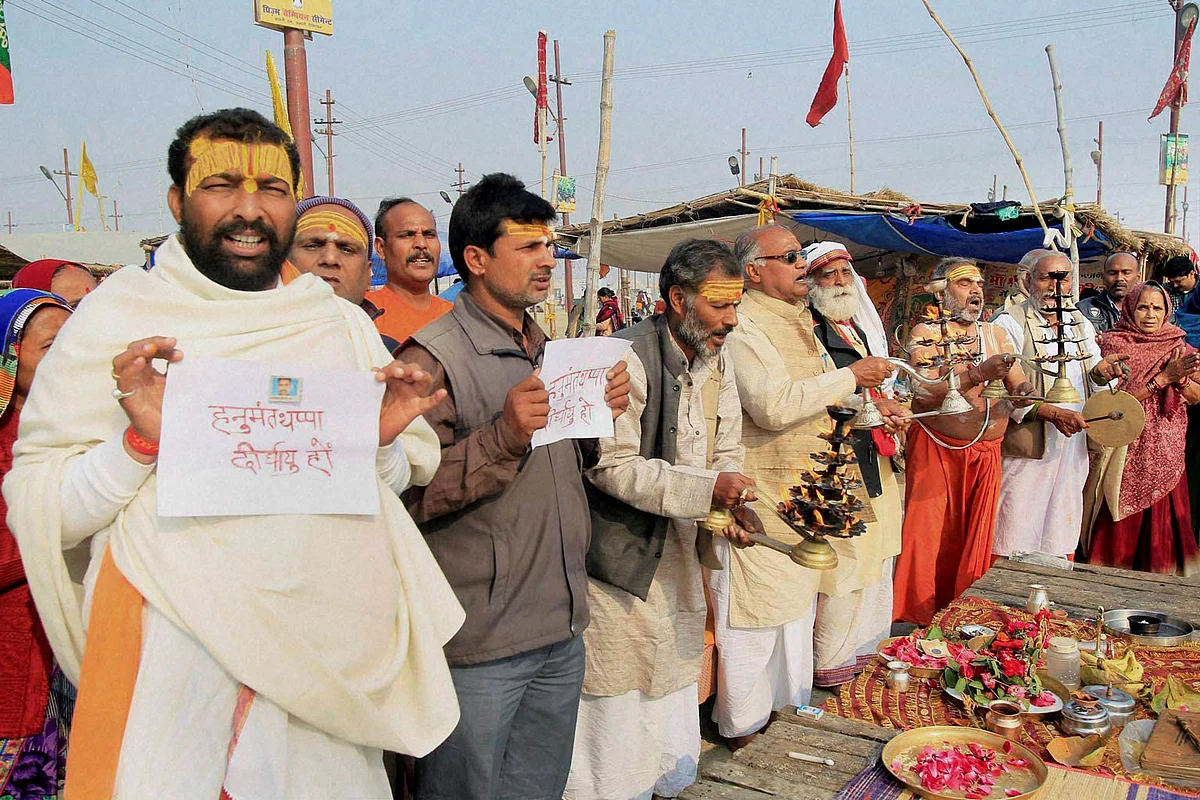 Devotees pray for Lance Naik Hanumanthappa Koppad on the river bank of Ganga in Allahabad. (Photo: PTI)