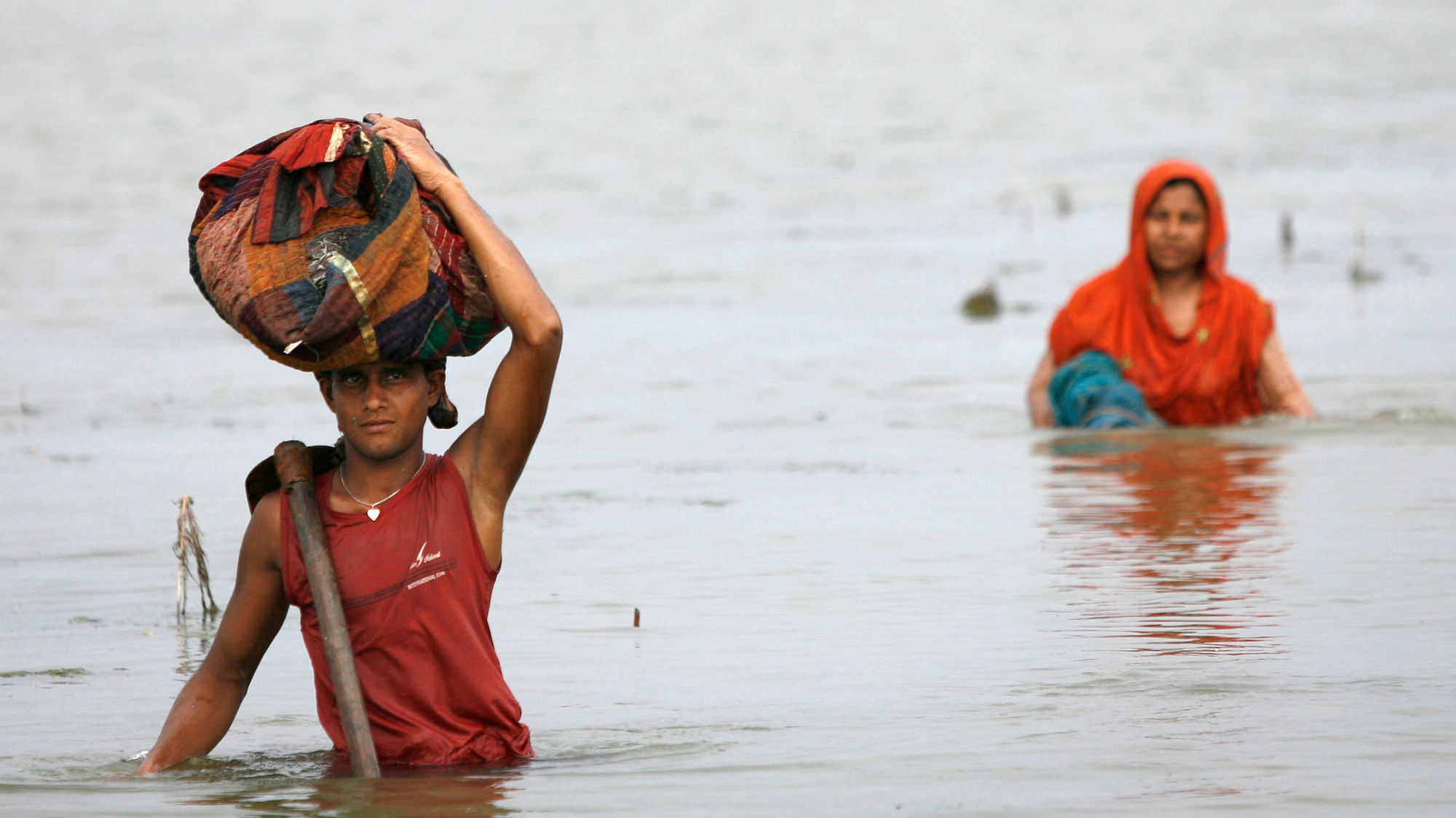 People carry their belongings through  floods caused by cyclone Aila in Shatkhira June 4, 2009. Thousands were displaced by a huge tidal wave caused by the storm. (Photo: Andrew Biraj/Reuters)