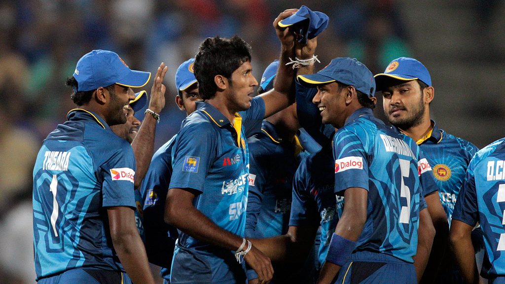 Kasun Rajitha celebrates a wicket with his teammates in the first T20 at Pune. (Photo: AP)