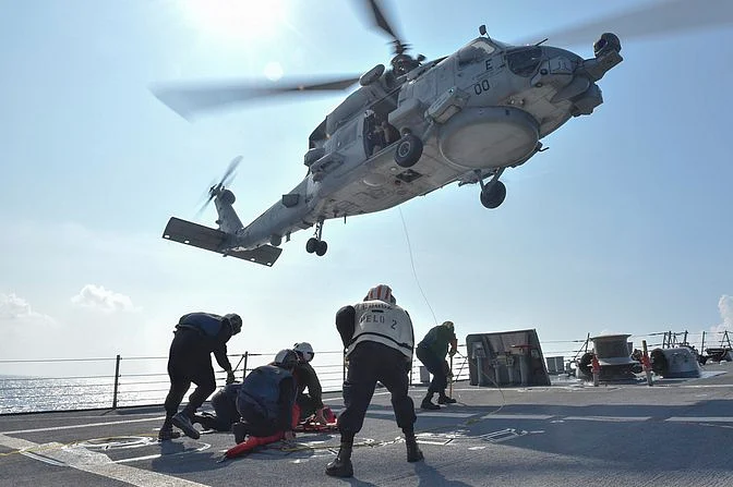 US Navy Sailors participate in a medical training exercise on the deck of the Arleigh Burke-class guided missile destroyer USS Lassen (DDG 82) with an MH-60R Seahawk helicopter in the South China Sea, 28 October 2015, provided by the US Navy. (Photo: Reuters)