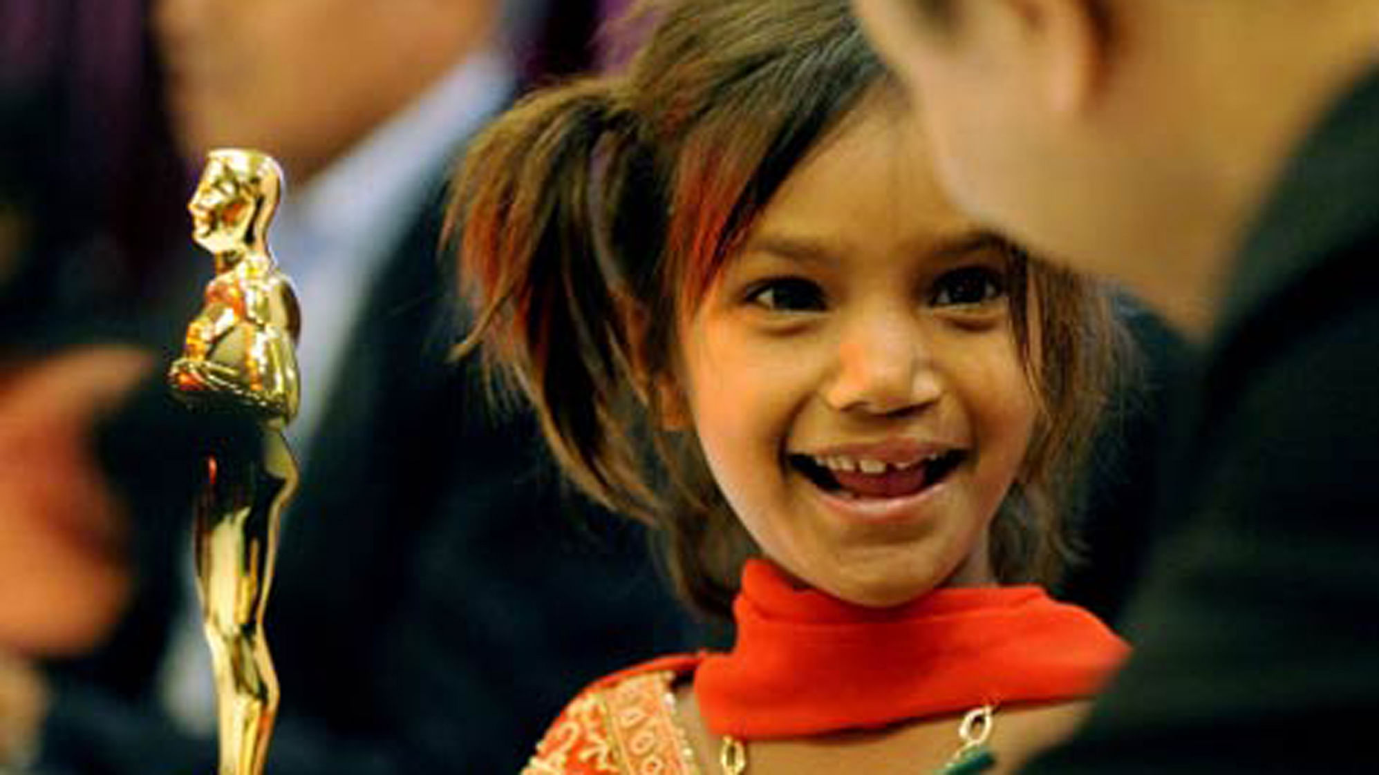 A photo of Pinki, after her cleft lip was surgically removed, with the Oscar for the documentary <i>Smile Pinki</i>. (Photo Courtesy: <a href="https://nimis540.wordpress.com/2009/02/24/smile-pinki-bringing-smile-to-thousands-of-kids-with-cleft-lips/">nimis540.wordpress.com</a>)