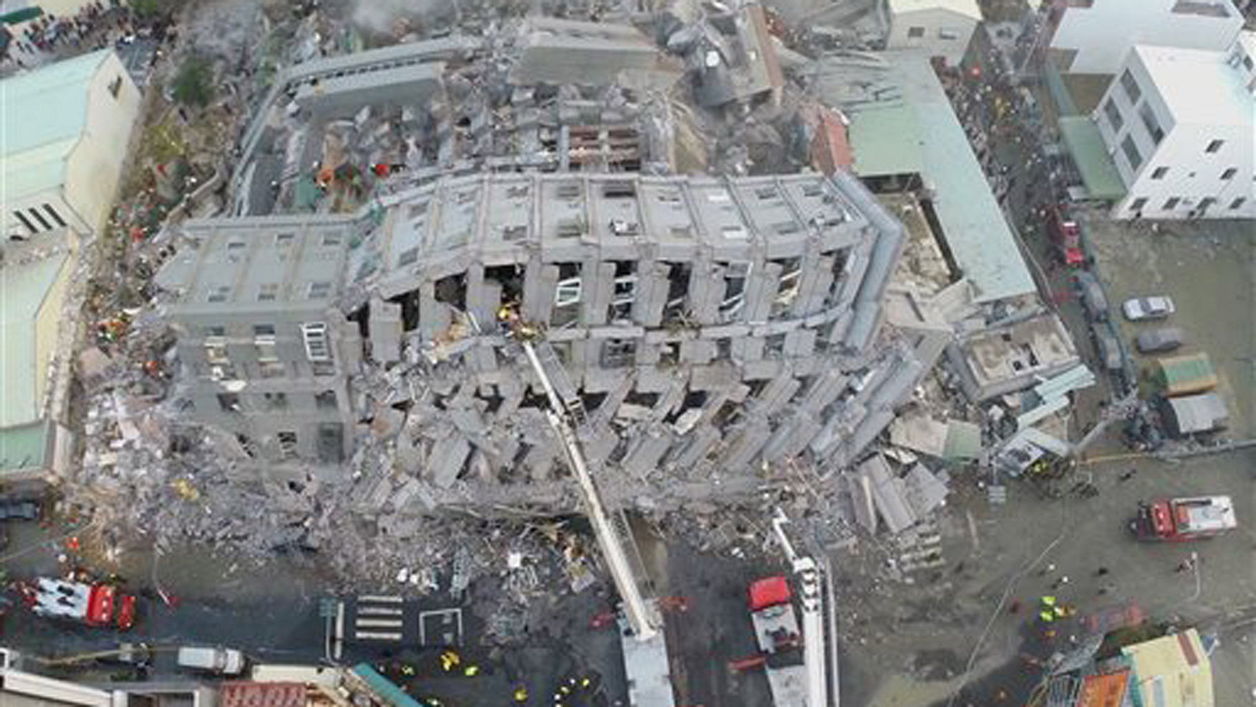 In this photo taken from a drone mounted camera, rescue workers search a collapsed building from an early morning earthquake in Tainan. (Photo: AP)