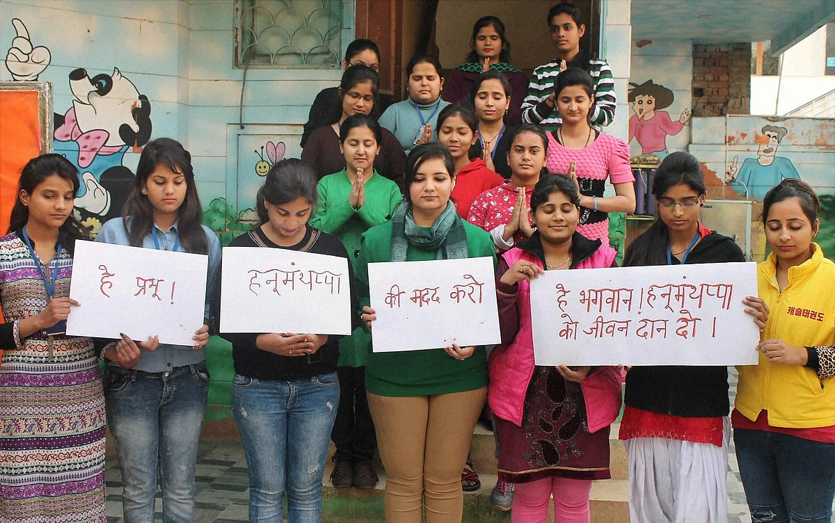 Students of Khazani Womens Vocational Institute pray for army man Hanumanthappa Koppad in Faridabad. (Photo: PTI)
