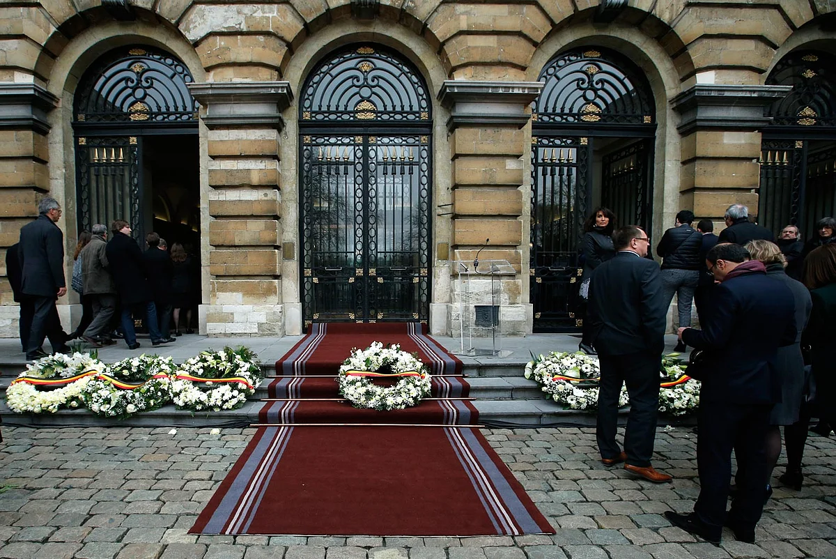 Belgian lawmakers walk past wreaths laid on the
grounds of the Parliament building in Brussels (Photo: AP)