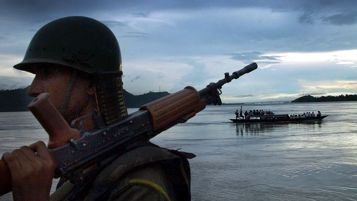 An Indian paramilitary trooper stands guard on the banks of Brahmaputra river on the outskirts of Guwahati, 12 August 2002. (Photo: Reuters)