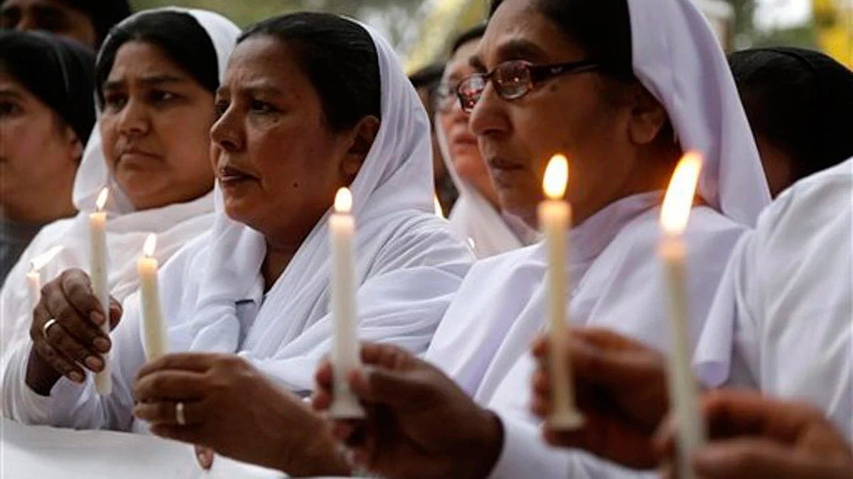 Pakistani nuns hold candles during a vigil for victims of Sunday’s deadly suicide bombing in a park. (Photo: AP/KM Chaudary)
