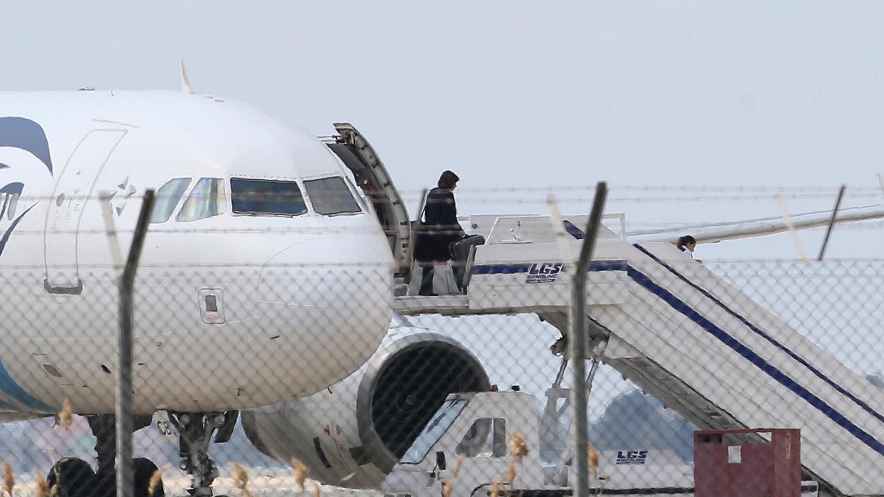 A passenger leaves the hijacked EgyptAir aircraft after landing at Larnaca Airport in Cyprus. (Photo: AP)
