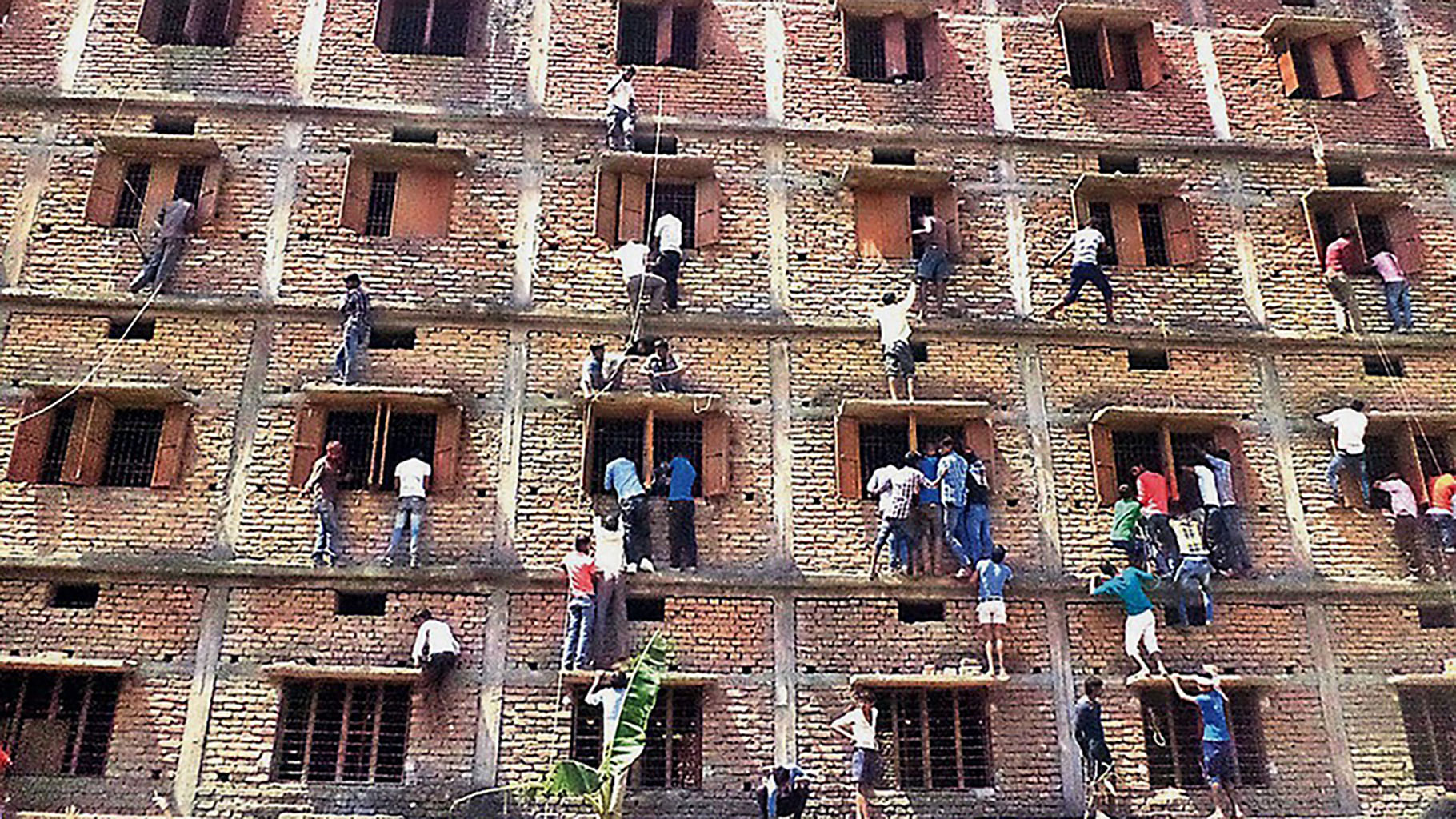 In this file photo, kin of class X examinees climbed many
floors to pass on books and chits in Bihar. (Photo: AP)