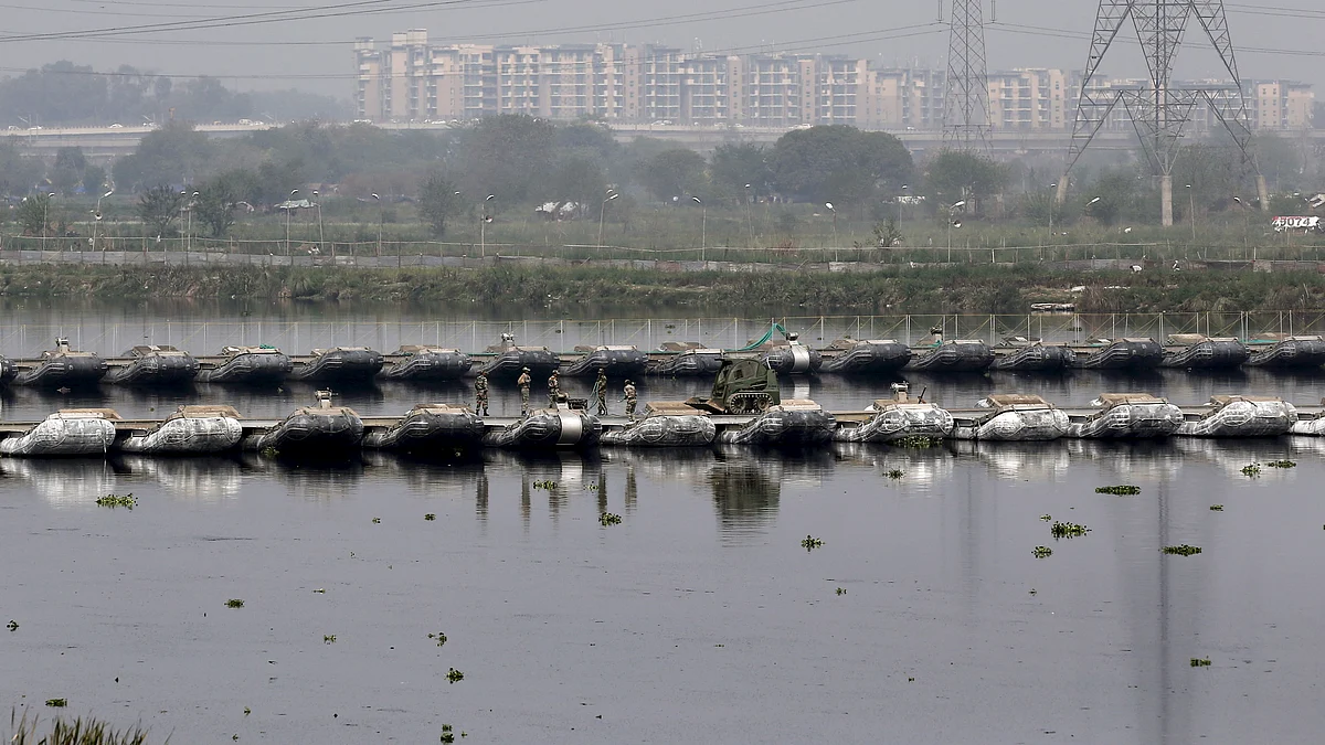 Army soldiers walk on a pontoon bridge laid on the waters of the Yamuna to reach the venue of the World Culture Festival. (Photo: Reuters)