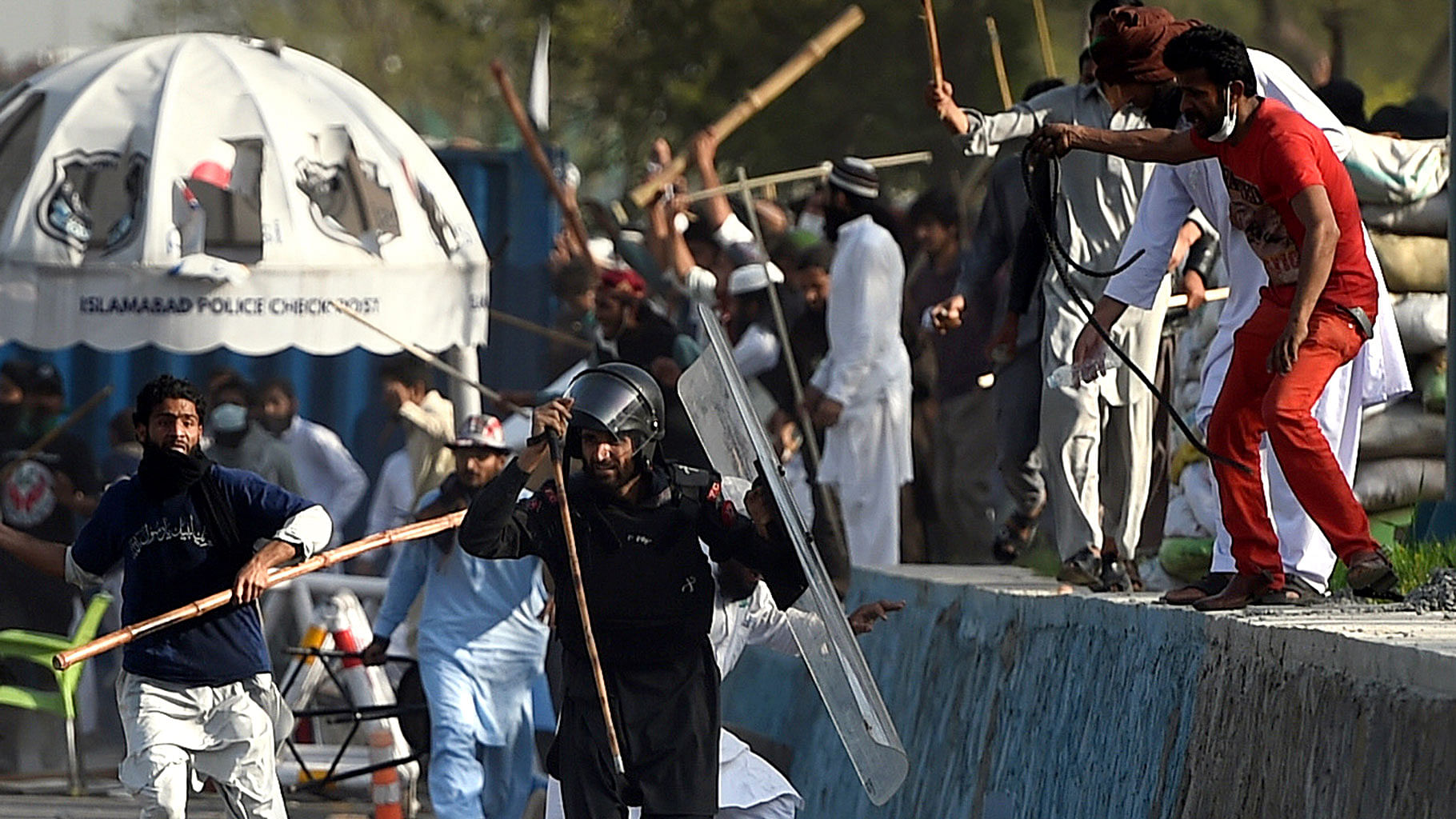 Pakistani protesters beat a paramilitary soldier during clashes near the parliament building in Islamabad, Sunday. (Photo: AP)