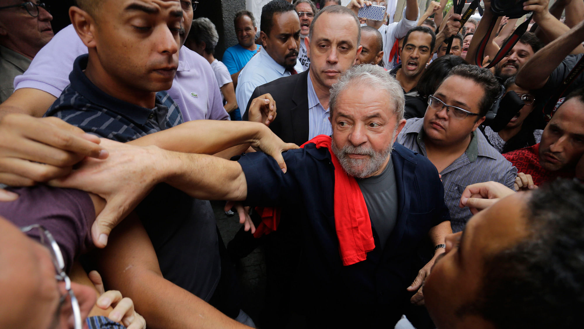 Police picked up Lula (centre) at his home on the outskirts of Sao Paulo and released him after three hours of questioning. (Photo: AP)