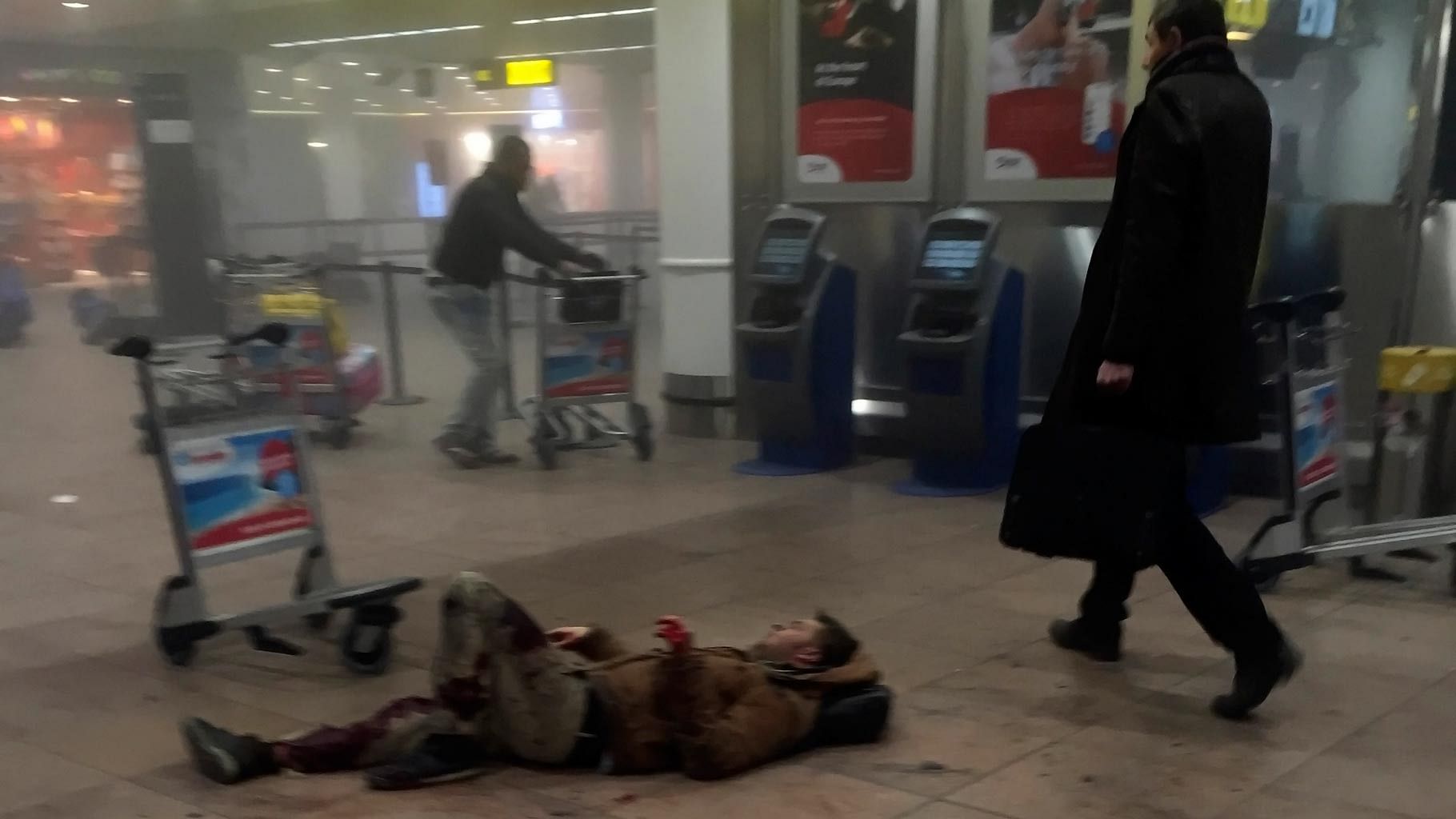 A man lies wounded on the floor of the Brussels Airport, Belgium, after explosions ripped through the departure hall Tuesday, March 22, 2016. (Photo: AP)