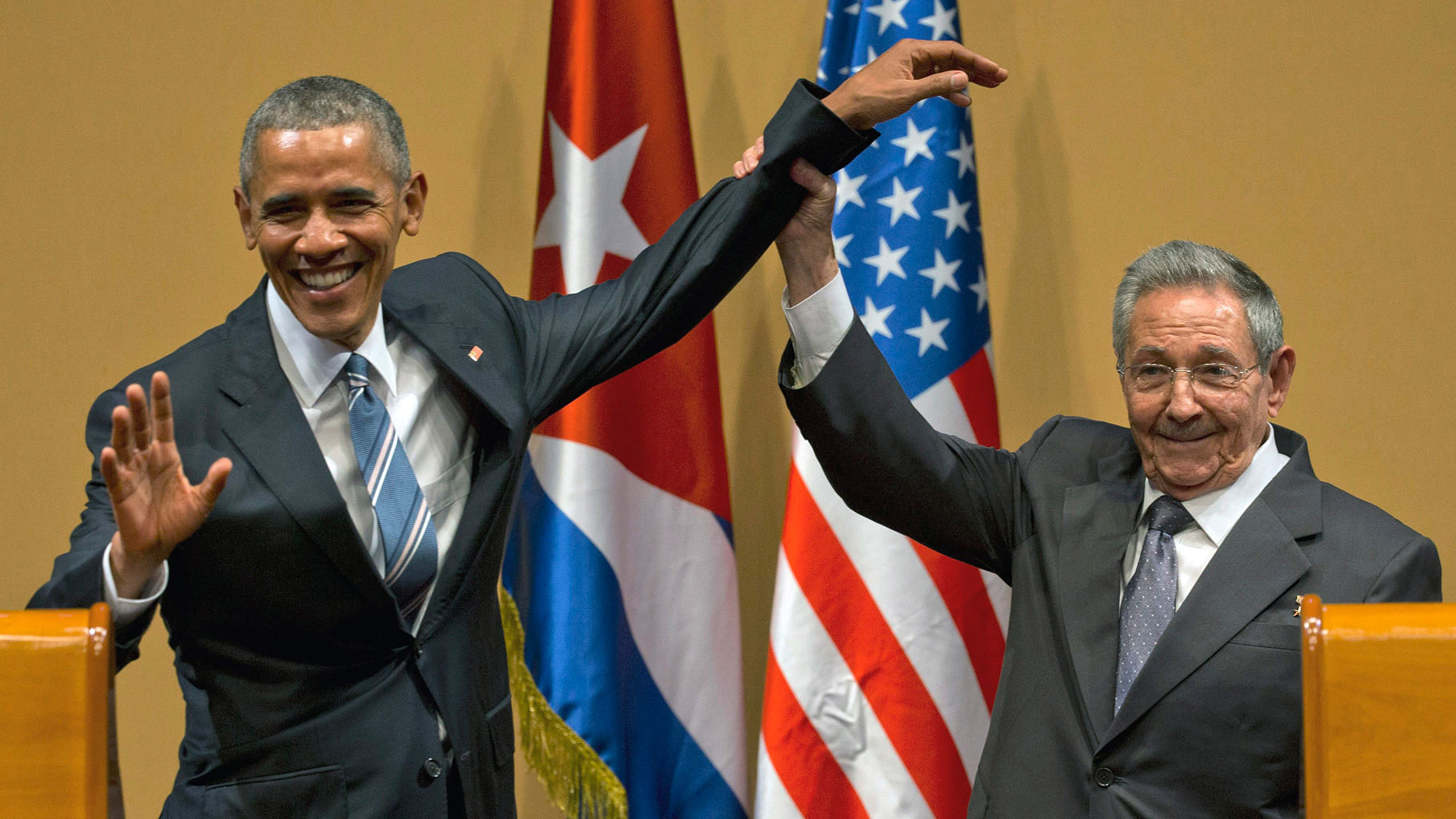 Cuban President Raul Castro, right, lifts up the arm of President Barack Obama at the conclusion of their joint news conference at the Palace of the Revolution. (Photo: AP)