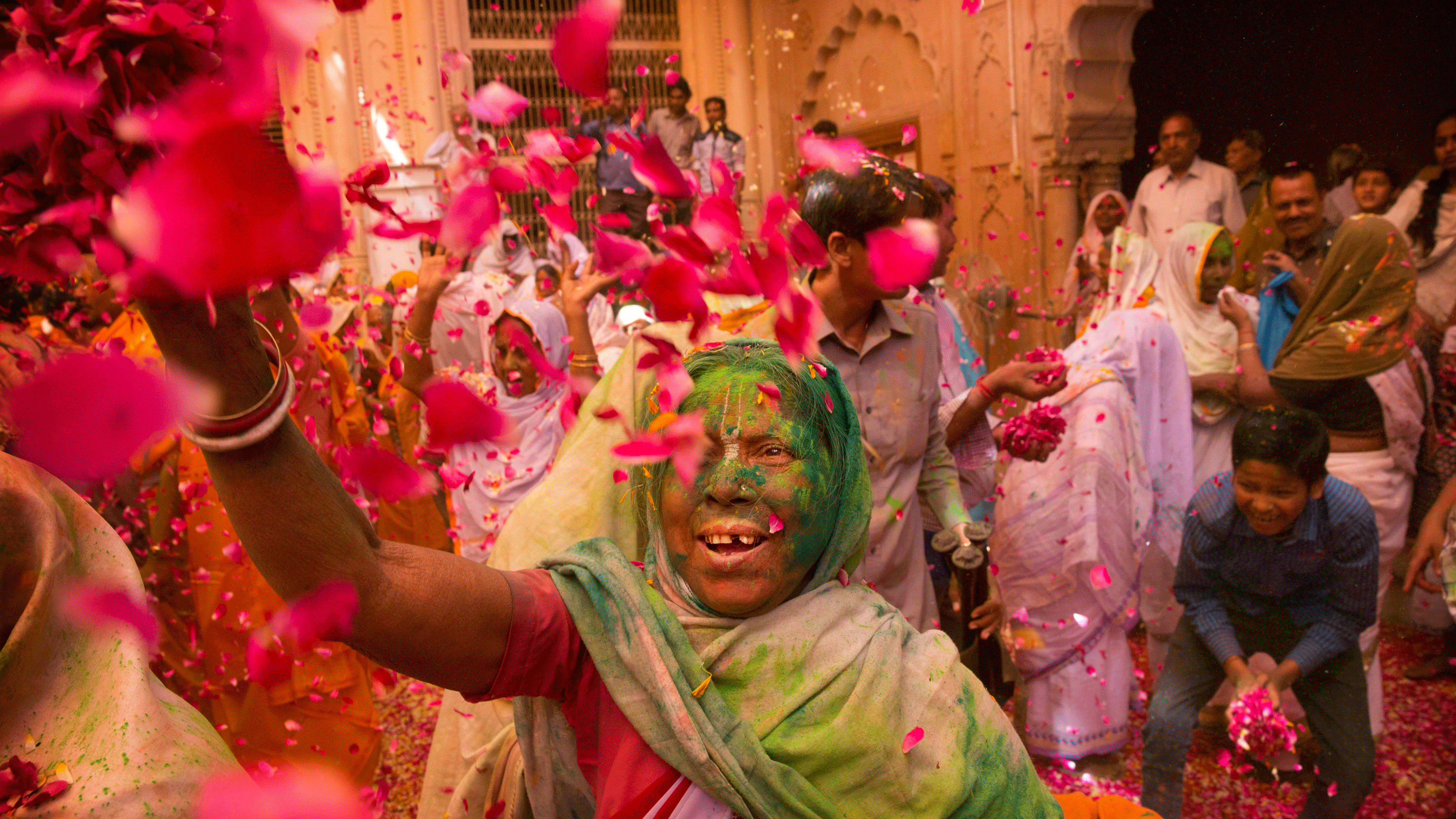 Widows throw flower petals and colored powder during Holi celebrations at the Gopinath temple, Vrindavan.