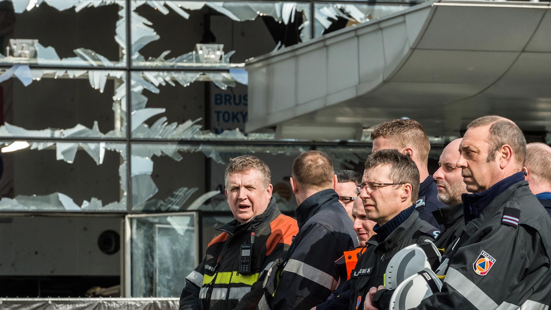 Firefighters and first responders stand next to blown out windows at Zaventem Airport in Brussels. (Photo: AP)
