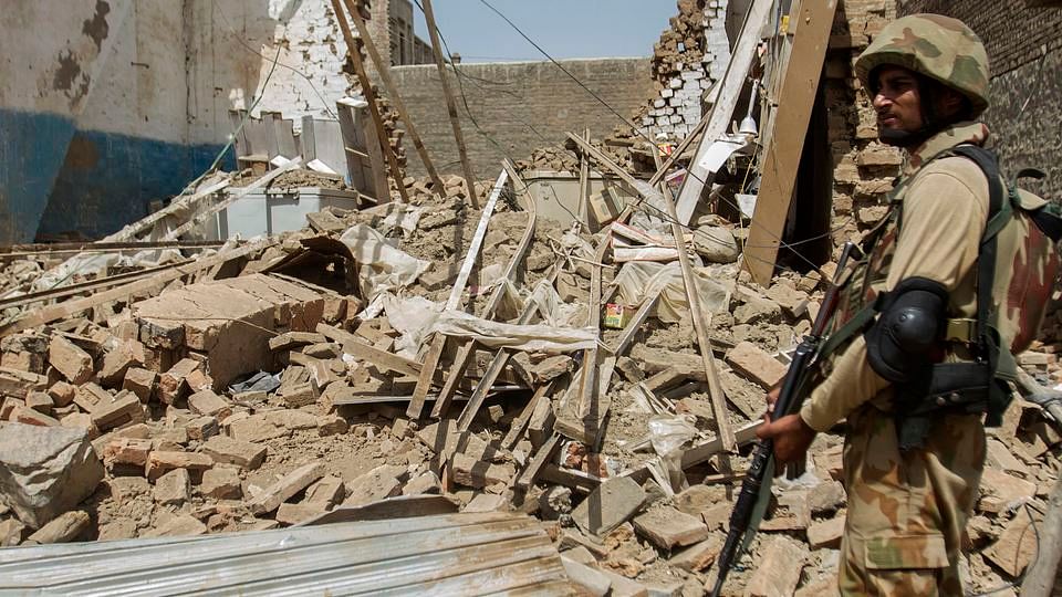 A Pakistani soldier stands beside a house which was destroyed during a military operation against Taliban militants, in North Waziristan  (Photo: Reuters)
