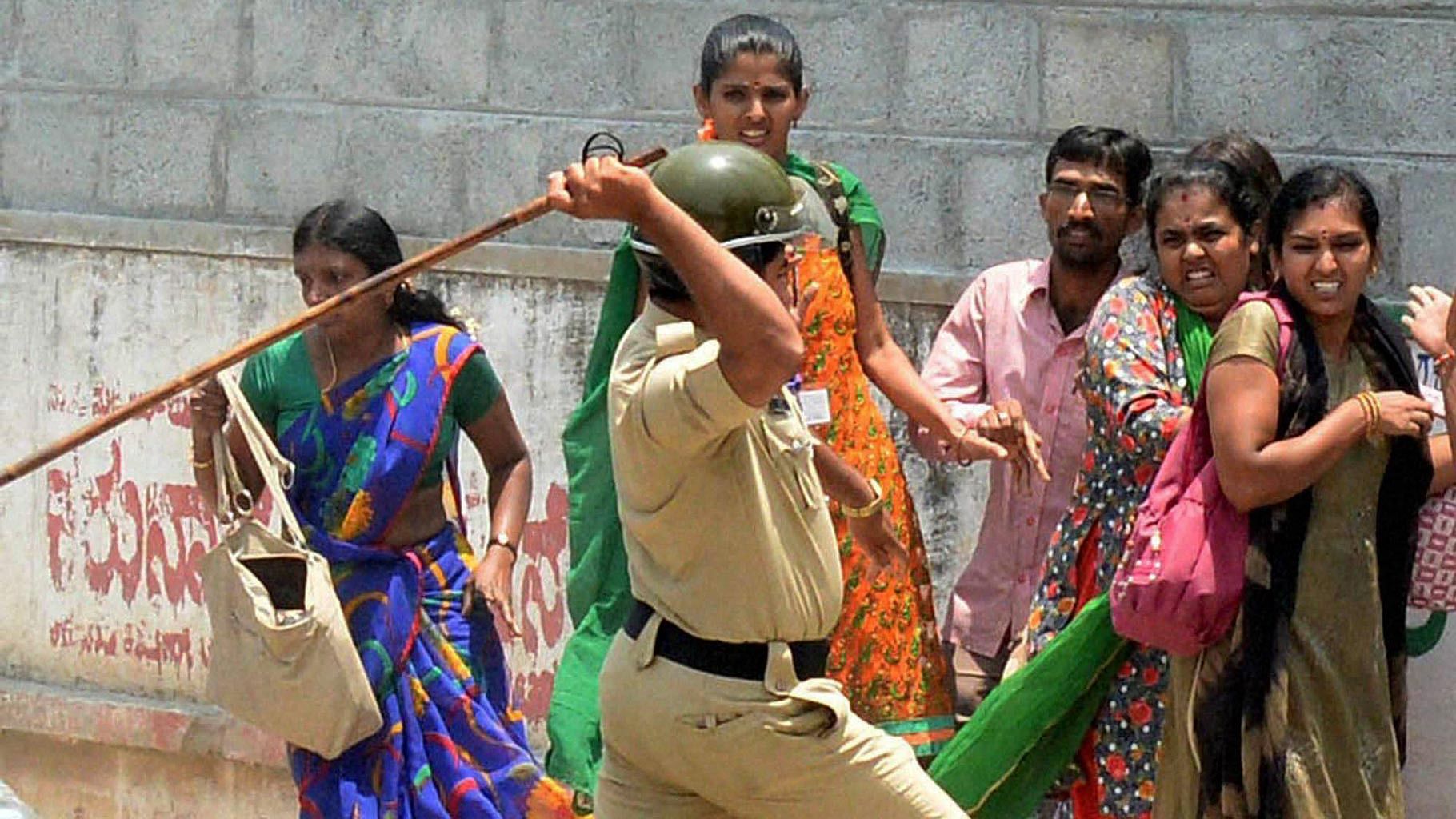 Police charge the garment factory workers who were protesting over EPF withdrawal norm, in Bengaluru on Tuesday.(Photo: PTI)