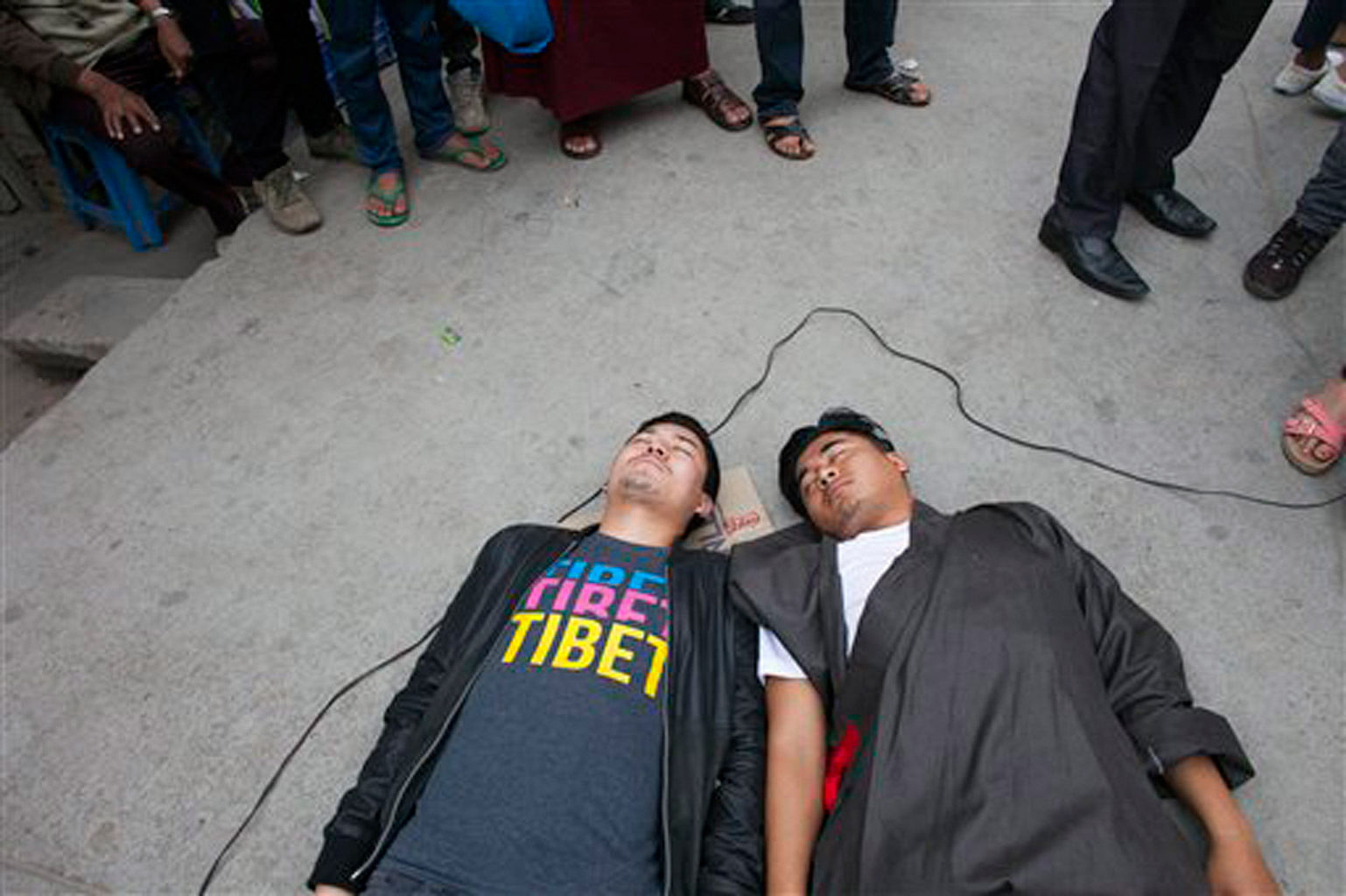 Tibetan activists represent the two Tibetans they claim were killed recently by Chinese police in Kardze, Tibet, during a street protest in Dharamsala, India, on Friday, 1 April 2016. Protesters  also claim that three Tibetans were arrested  for discussing the recent Tibetan elections in exile on social media in Tibet. (AP Photo/Ashwini Bhatia)