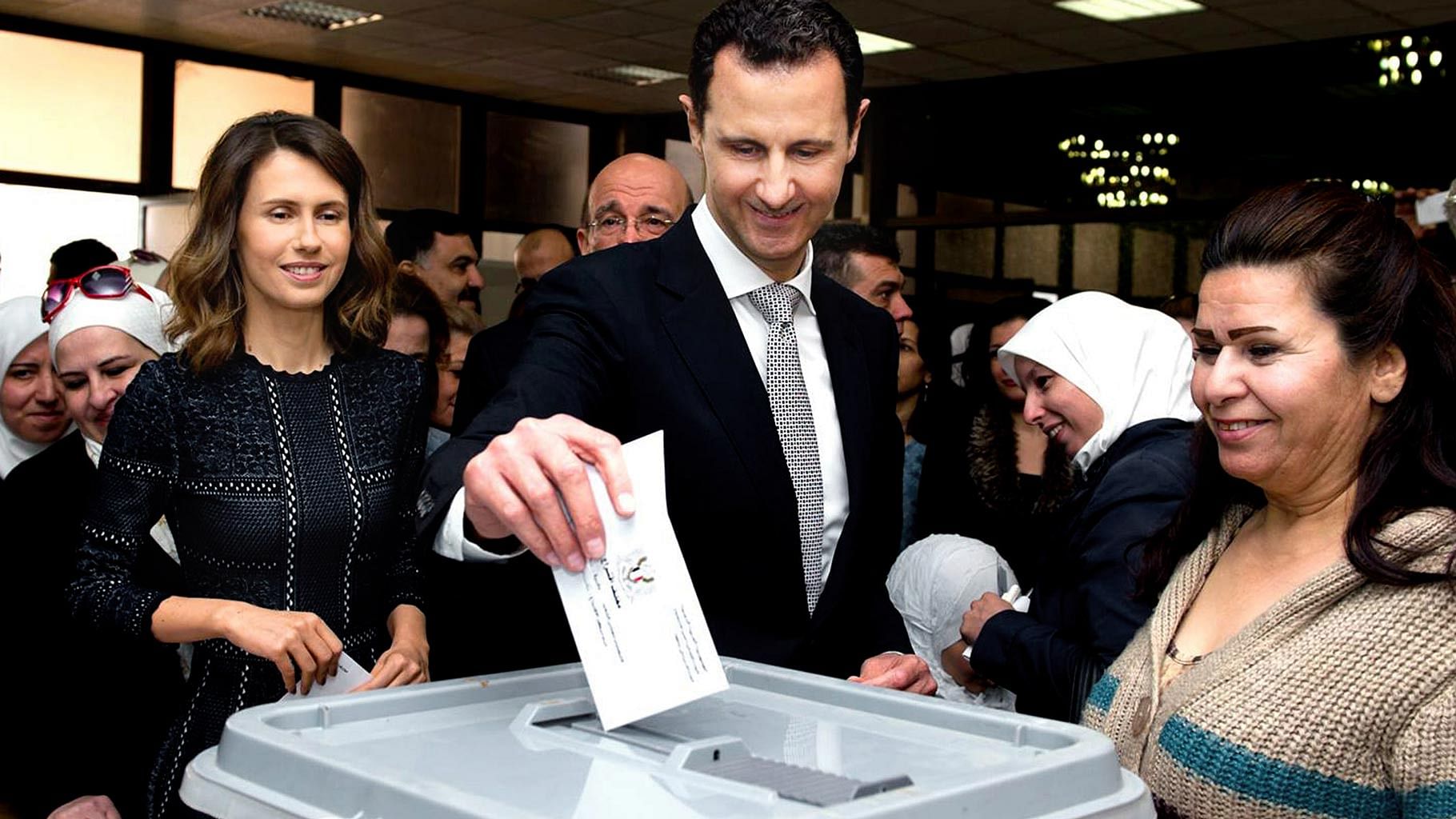 Syrian President Bashar Assad casting his ballot in the parliamentary elections, as his wife Asma, left, stands next to him, in Damascus, Syria, 13 April  2016. (Photo: AP)