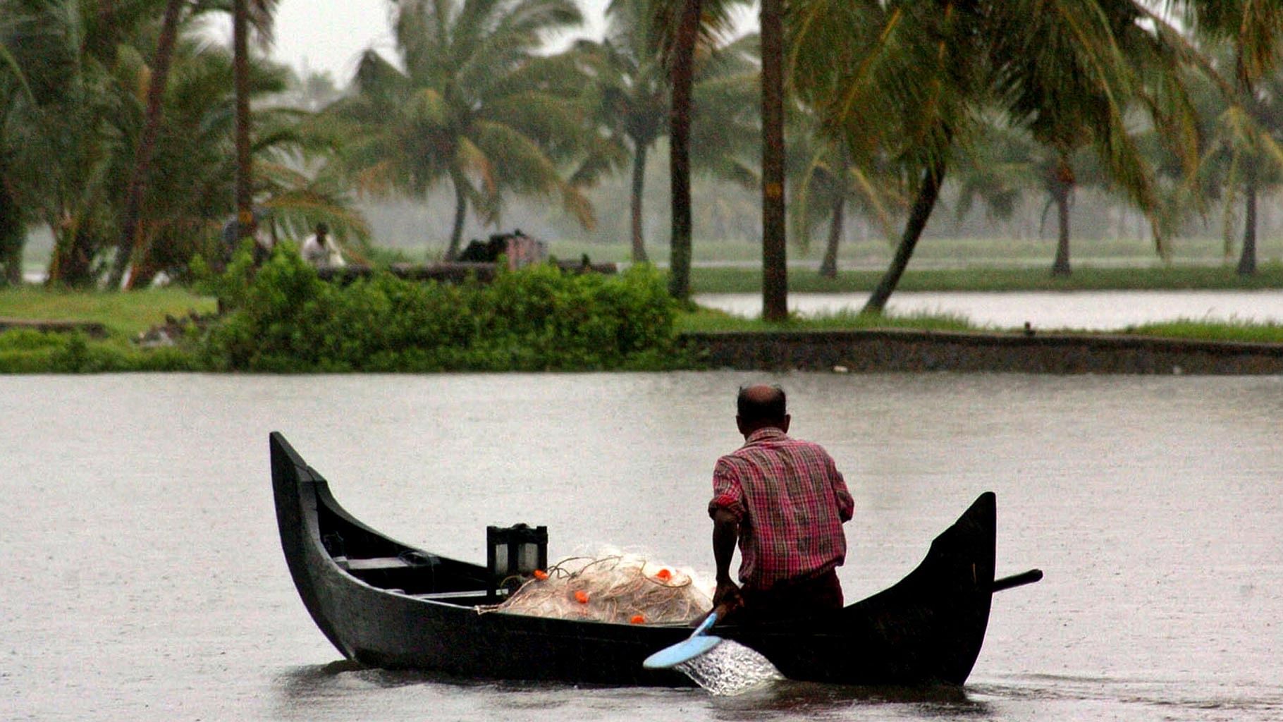 File photo of a fisherman rowing his boat during monsoons in Alleppy, Kerala.