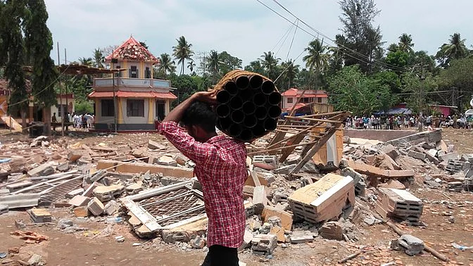 A man carries firecrackers from the site of the Puttingal temple fire tragedy. (Photo: AP)