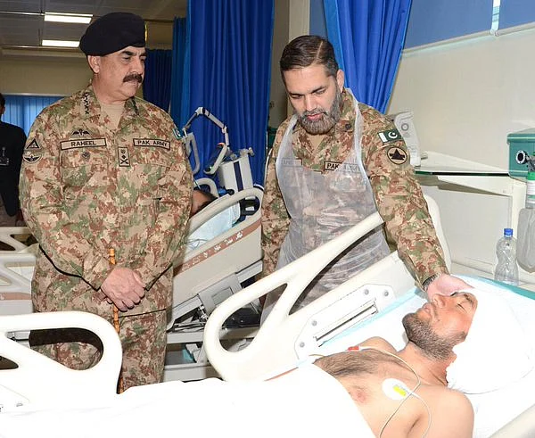 Asim Bajwa with an injured soldier. (Photo: <a href="https://twitter.com/AsimBajwaISPR/status/703841632219627520">Twitter/@AsimBajwaISPR</a>)