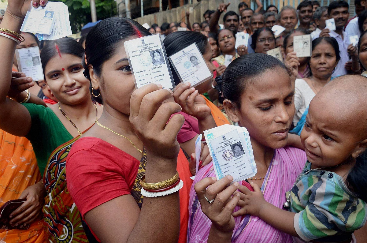 Voters show their voter cards at a polling station during 3rd phase of state assembly elections in Kolkata. (Photo: PTI)