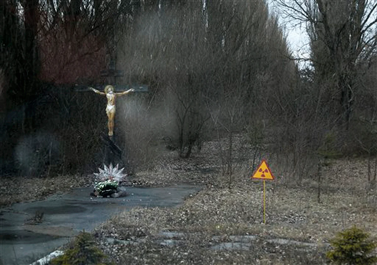 A crucifix and a radiation warning sign at the entrance to Pripyat, a scene of hushed desolation and frozen time. (Photo: AP)