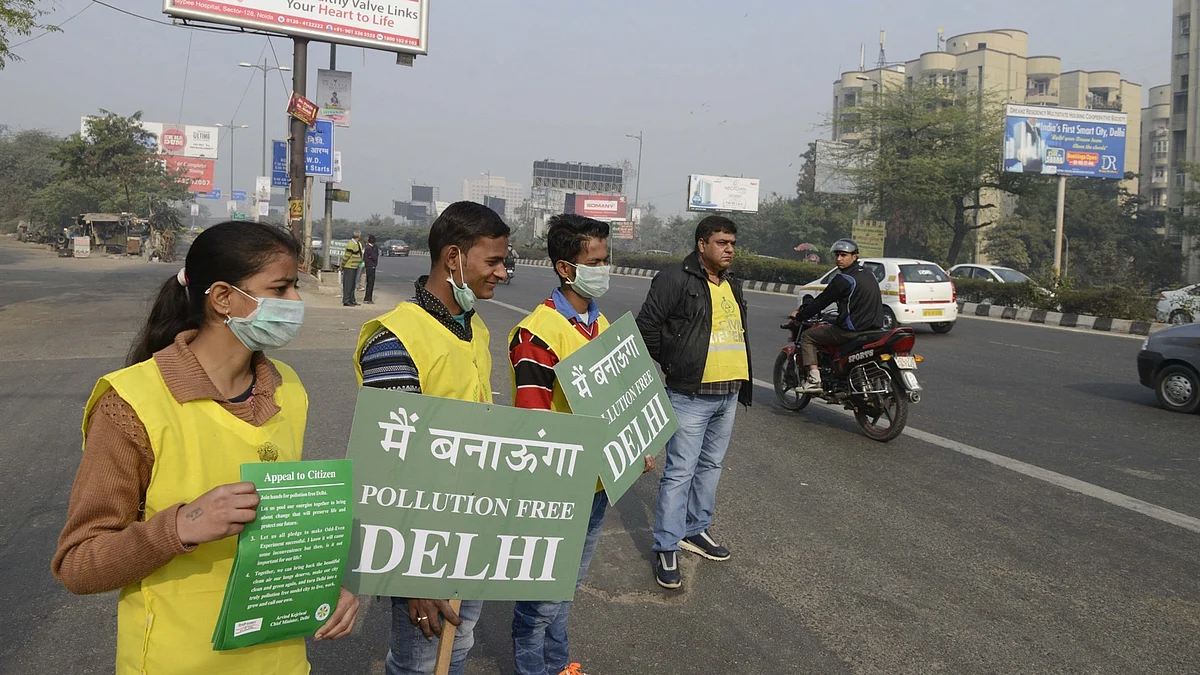 Volunteers stand on Delhi roads holding placards during Odd-Even Phase 2. (Photo: IANS)