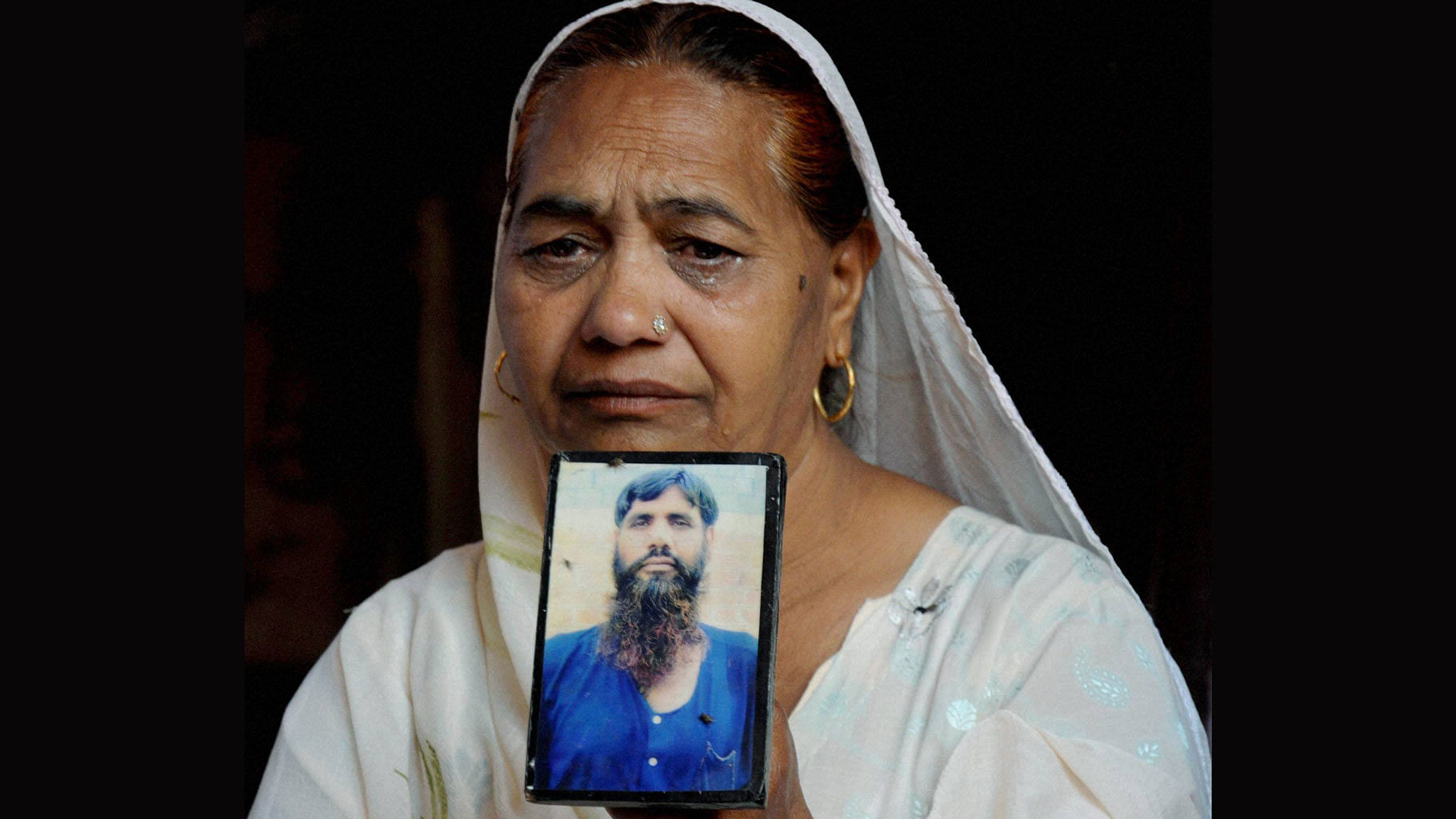 Jagir Kaur,  Kirpal Singh’s sister, cries as she shows his photograph while mourning the news of his death in Amritsar on Tuesday. (Photo: PTI)