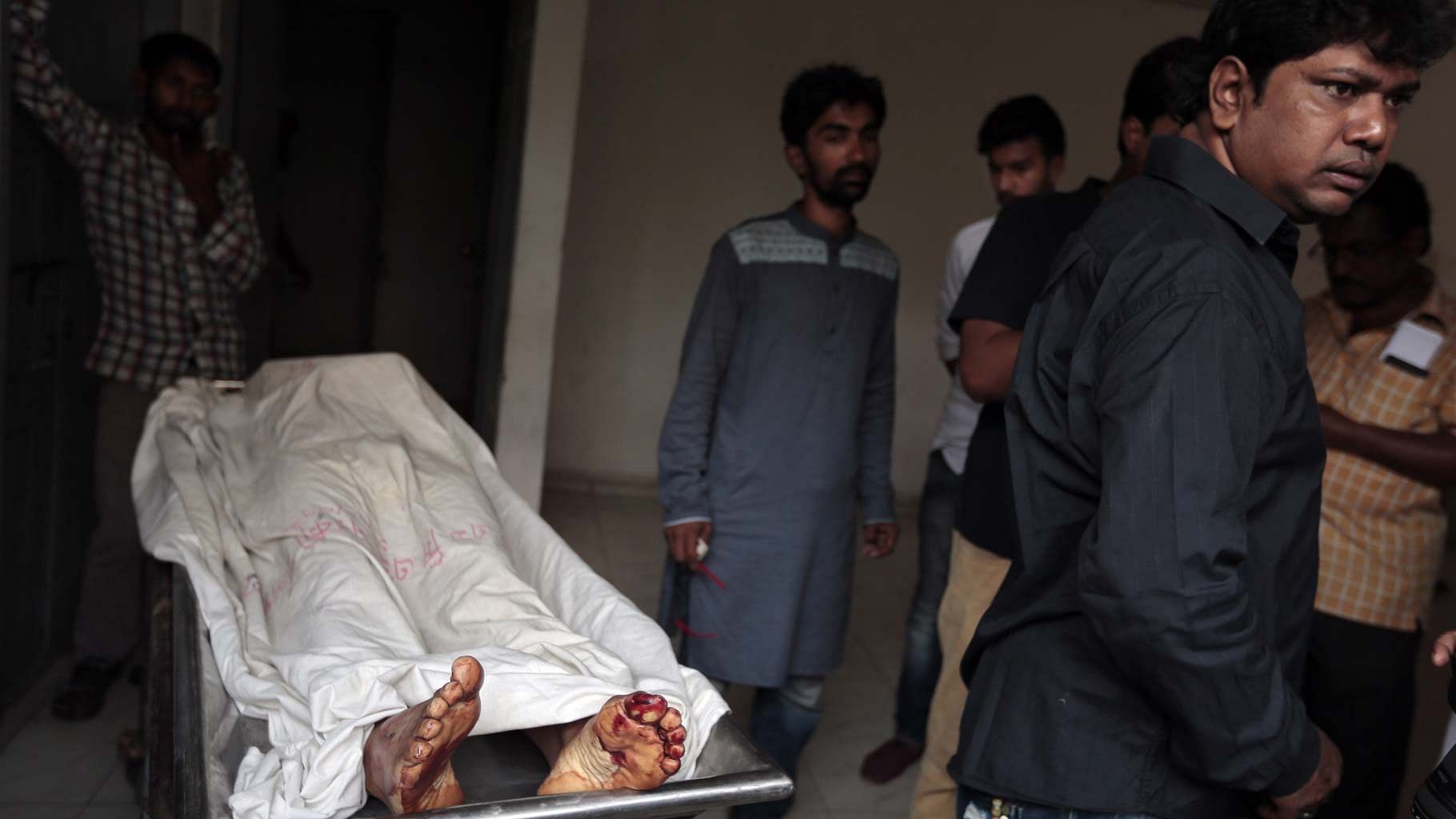The body of Xulhaz Mannan, who was stabbed to death by unidentified assailants, being carried out of a hospital morgue in Dhaka. (Photo: AP)