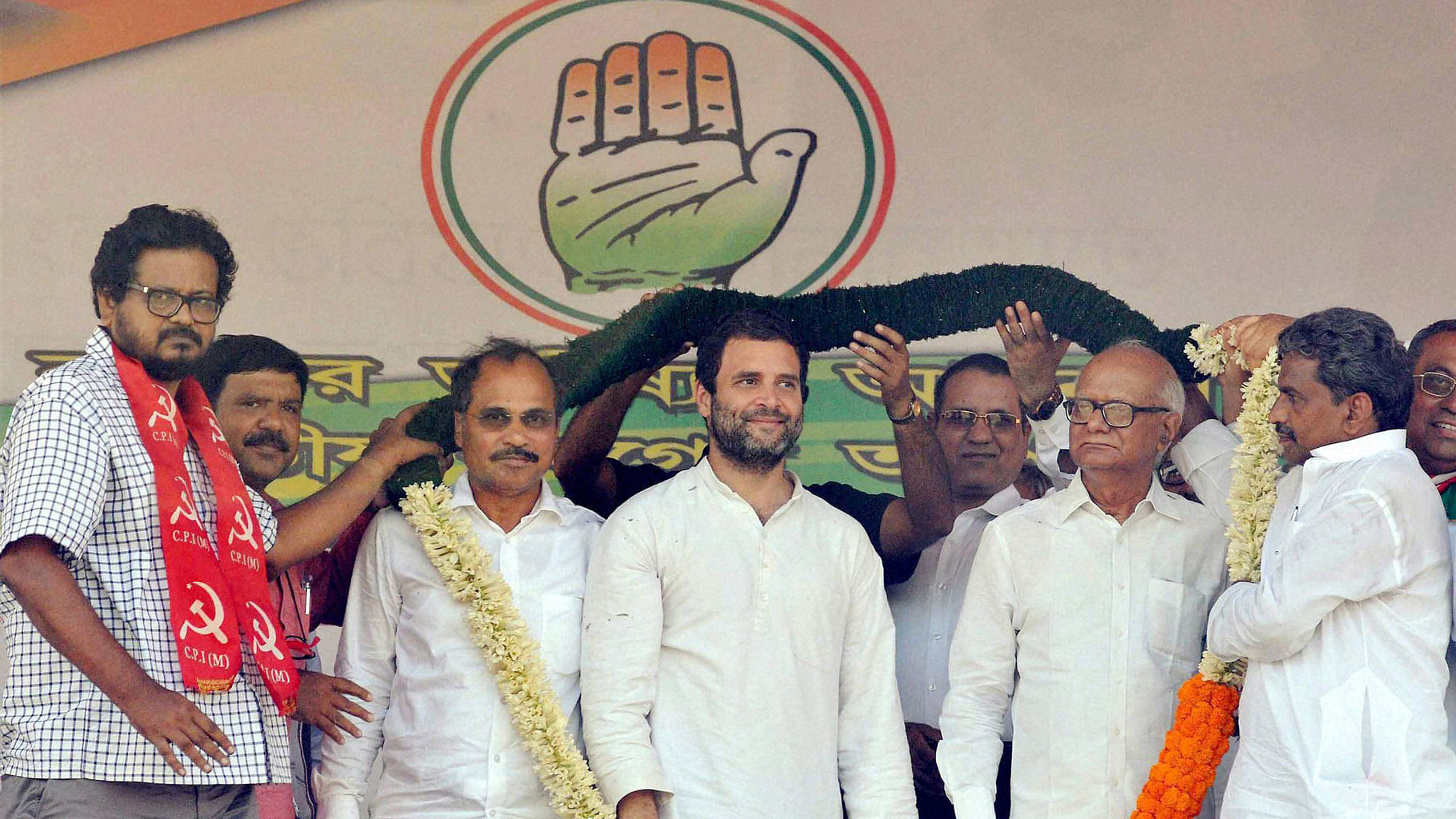 Congress Vice-President Rahul Gandhi being garlanded by CPI(M)-Congress joint candidates Anjan Bera (L) and Santosh Pathak (R)  during an election campaign rally in Howrah on Saturday. To Rahul’s left is West Bengal Congress chief and Lok Sabha MP Adhir Ranjan Chowdhury. (Photo: PTI)