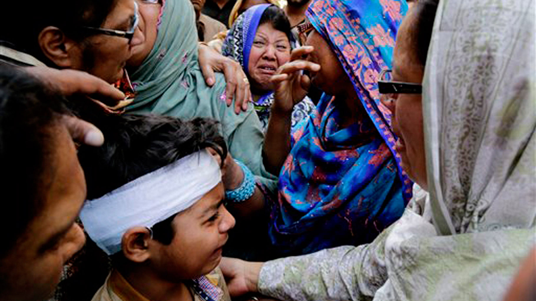 

Eric John, bottom, who survived Sunday’s attack, cries during the funeral of his cousin, in Lahore. (Photo: AP/KM Chaudary)