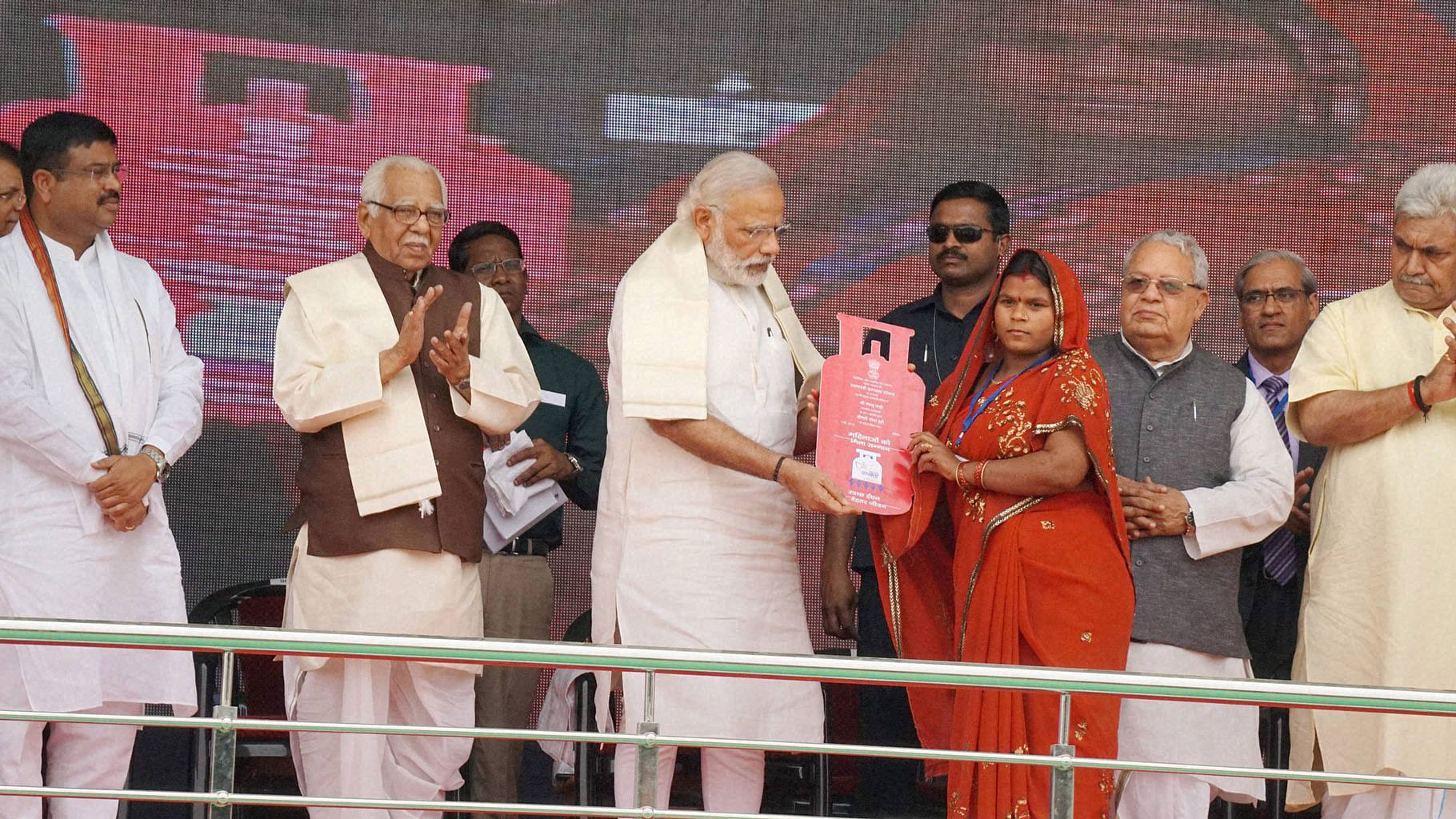Prime Minister Narendra Modi presents cooking gas connection to a woman of a Below Poverty Line (BPL) family during the launch of the Pradhan Mantri Ujjwala Yojana in Ballia on Sunday. (Photo: PTI)