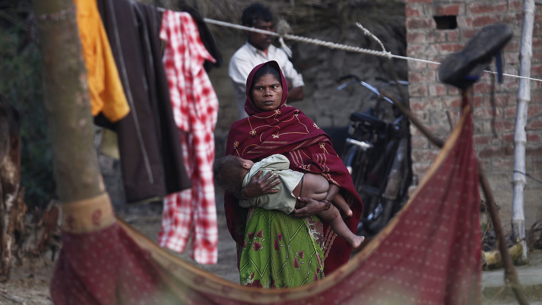 A woman holds her child as she stands outside her house in a dalit village. (Photo: Reuters)