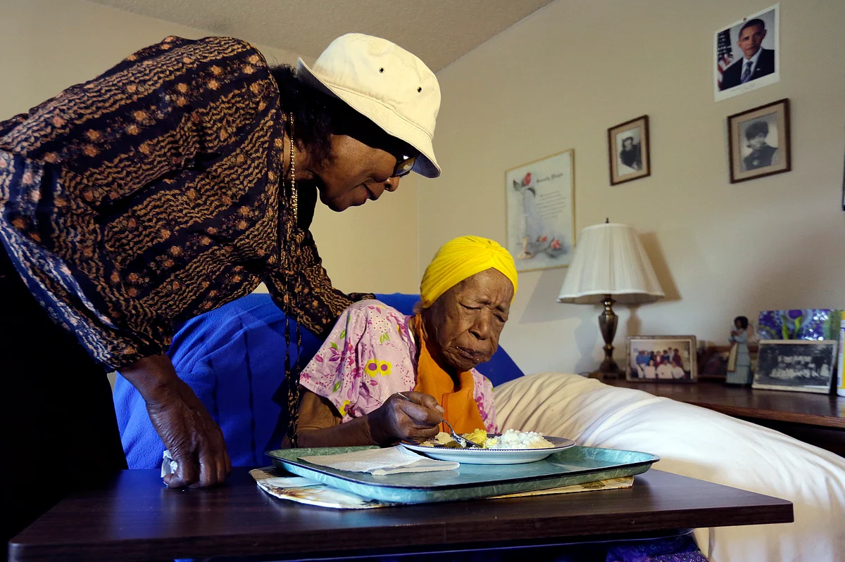 Lois Judge helps her aunt Susannah Mushatt Jones,right, during breakfast in Jones’ room in New York, 2015. (Photo: AP)