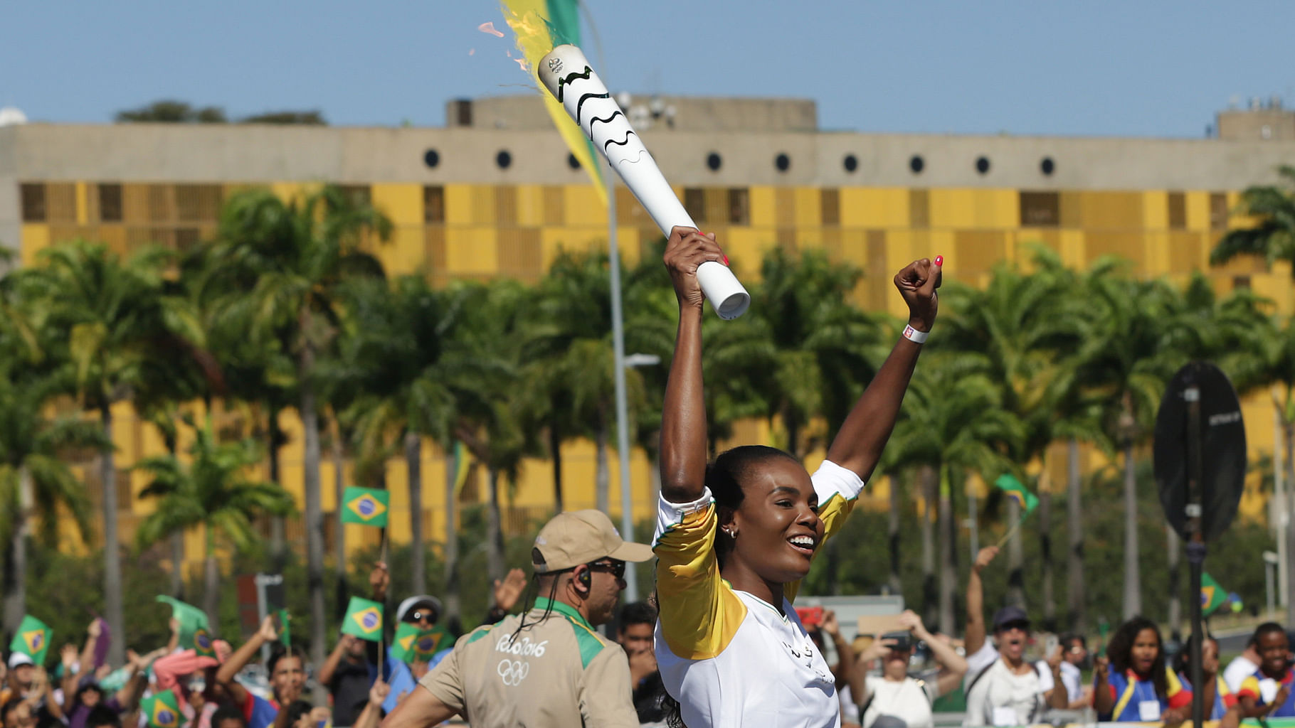 Brazilian volleyball player Fabiana Claudino holds the Olympic torch after the torch lighting ceremony at Planalto presidential palace in Brasilia. (Photo: AP)