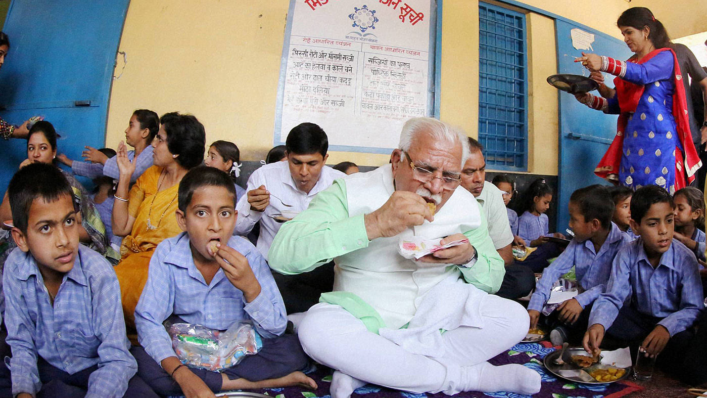 Haryana CM ML Khattar eating with students on his birthday. (Photo: PTI)