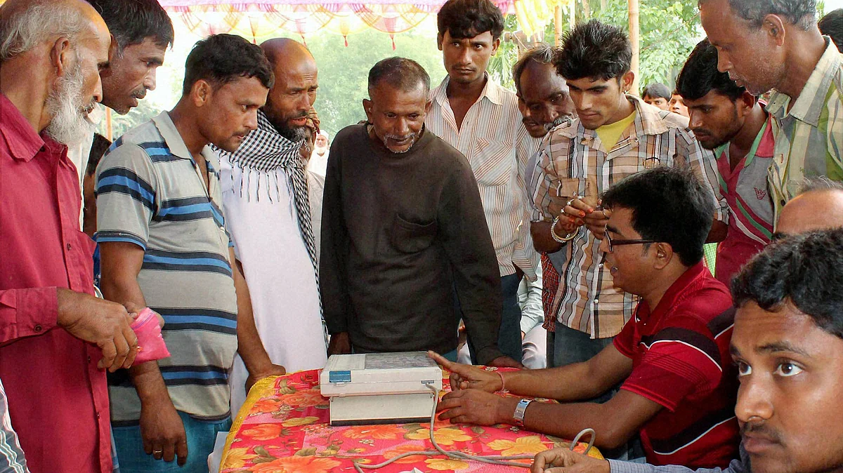 Election commission officials demonstrating the handling of EVM to the enclave dwellers in West Bengal, 26 April 2016. (Photo: PTI)