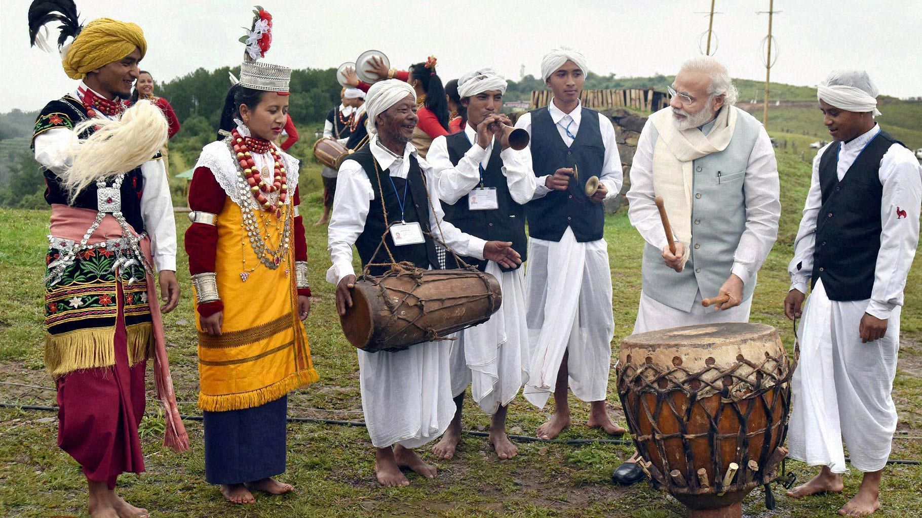 Prime Minister Narendra Modi playing drums with tribal musicians (Photo: PTI).