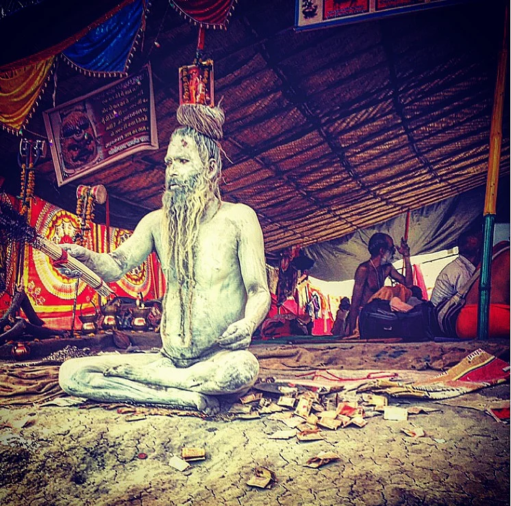 Nagasadhus smeared in ash sit with the ‘blessing broom’ at the Simhastha Ujjain Kumbh Mela 2016. (Photo: Rishika Baruah/The Quint)