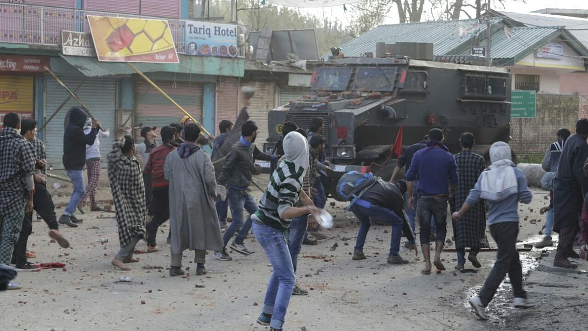 People pelt stones on an army vehicle a day after two people were killed in army firing in Handwara of Jammu and Kashmir, 13 April 2016. (Photo: IANS)