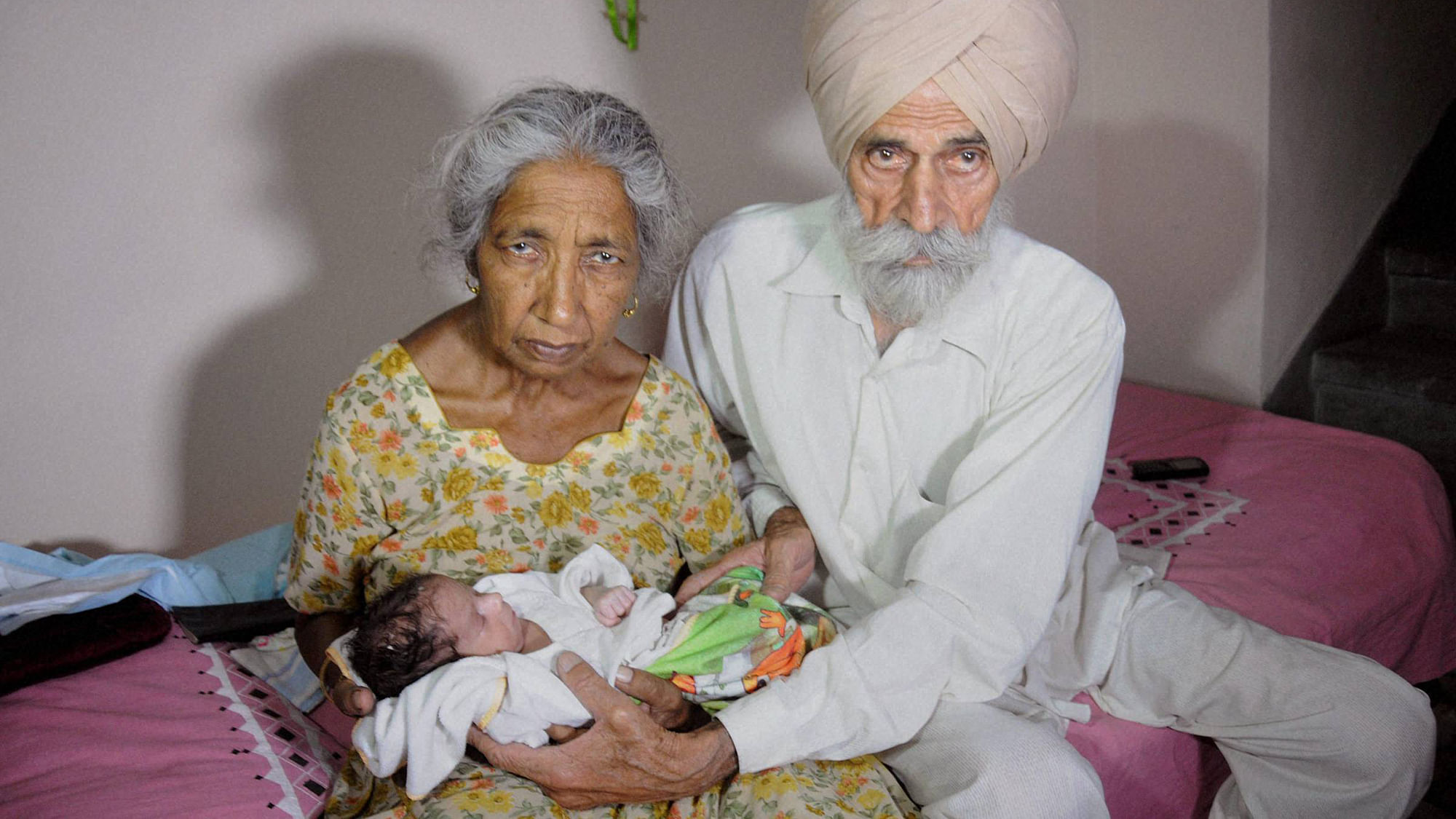 Parents Mohinder Singh Gill (R), 79, and Daljinder Kaur, 72, pose for a photograph as they hold their newborn baby boy Armaan at their home in Amritsar Wednesday. (Photo: PTI)