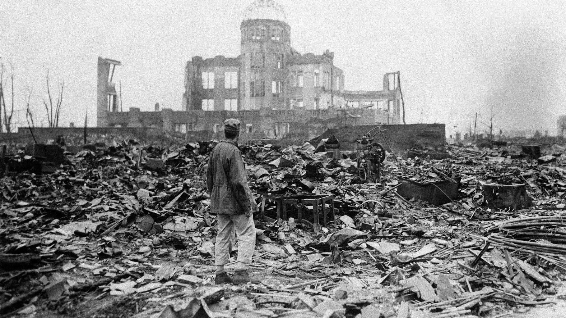 An allied correspondent stands in the rubble in front of the shell of a building that once was a movie theater in Hiroshima, Japan, a month after the first atomic bomb ever used in warfare was dropped by the US on 6 August 1945. In a moment seven decades in the making, President Barack Obama this month will become the first sitting American president to visit Hiroshima. (AP Photo/Stanley Troutman)