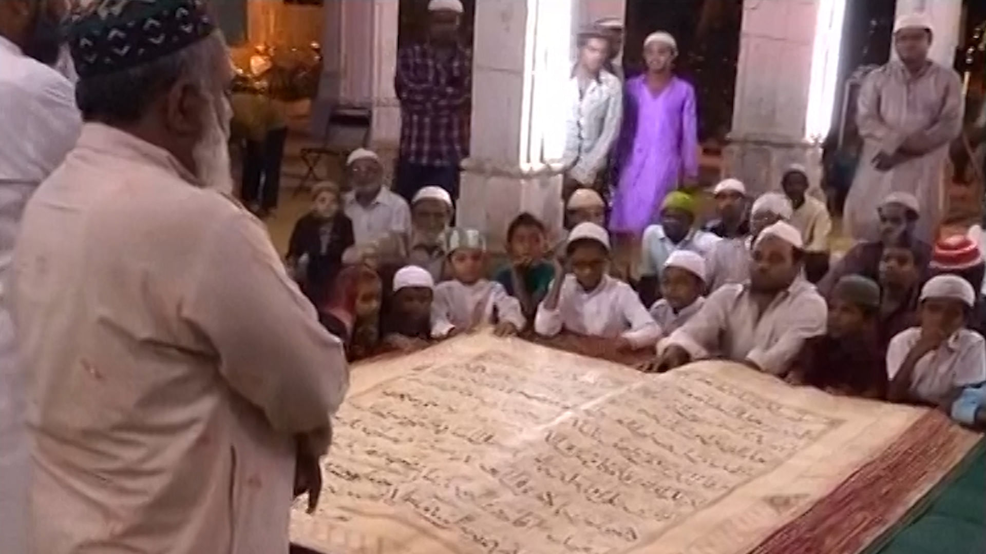 Devotees at Juma Masjid in Vadodara with the world’s largest Quran. (Photo: ANI Screengrab)