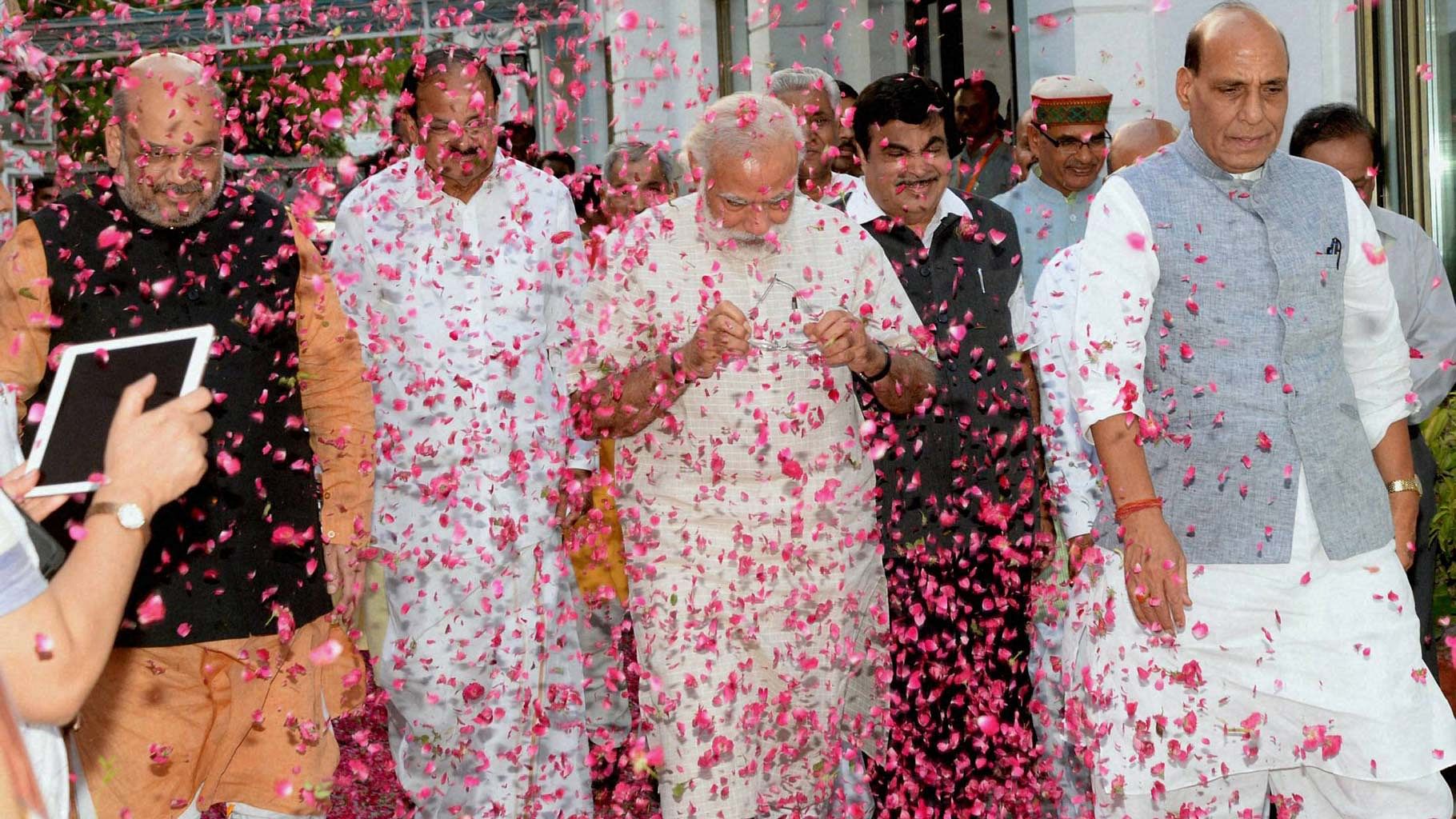 BJP workers shower flower petals on Prime Minister Narendra Modi, BJP president Amit Shah and senior leaders Rajnath Singh and M Venkaiah Naidu at the party office in New Delhi on Thursday, 19 May 2016. (Photo: PTI)