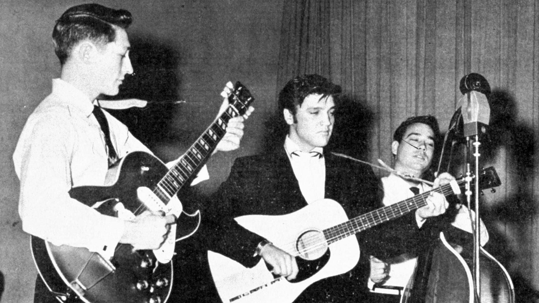 File photo, Elvis Presley performs on tour in the summer of 1957, with Scotty Moore on guitar (left) and Bill Black on the stand up bass, right. (Photo: AP)