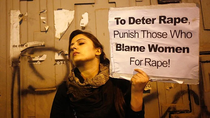 A demonstrator holds a placard as she attends a candlelight vigil to mark the first anniversary of Delhi gangrape. (Photo: Reuters)