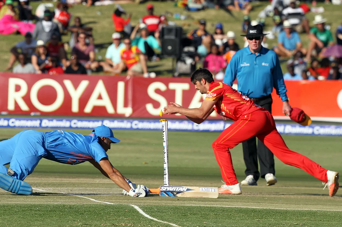 Indian batsman MS Dhoni, left, dives to avoid a run out during the T20 International cricket match against Zimbabwe. (Photo: AP)