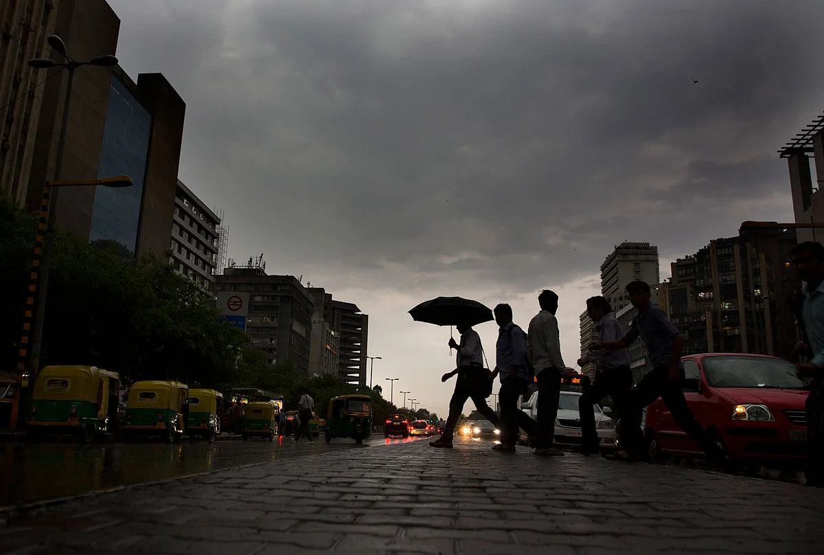 Indian commuters walk home in the rain in New Delhi. (Photo: AP)